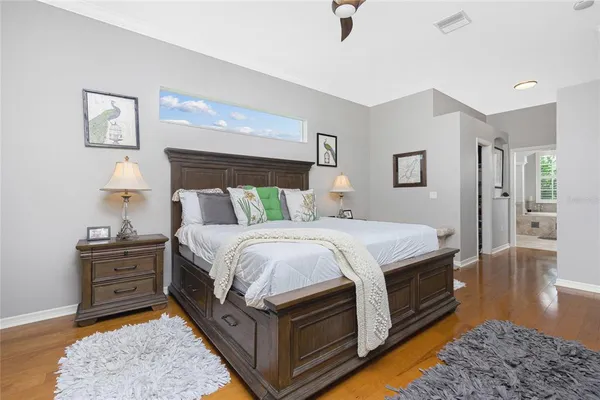 a bedroom with a bed and wooden floor