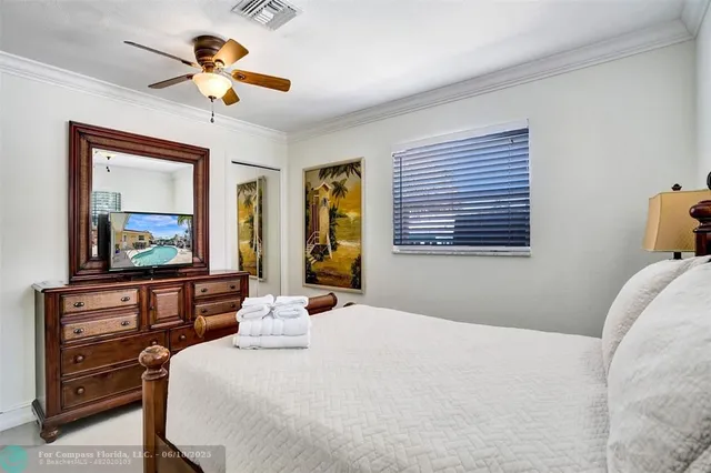 a bedroom with a bed and a chandelier with a flat tv screen