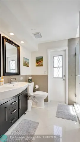 a spacious bathroom with a toilet a sink and mirror