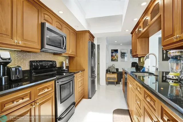 a kitchen with stainless steel appliances granite countertop a stove a sink and a microwave