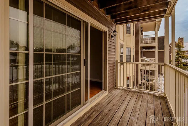 a view of a balcony with wooden floor and fence