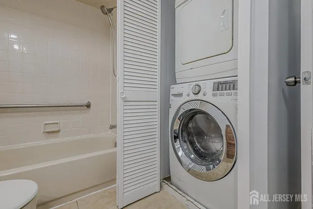a bathroom with a washer and a bathtub