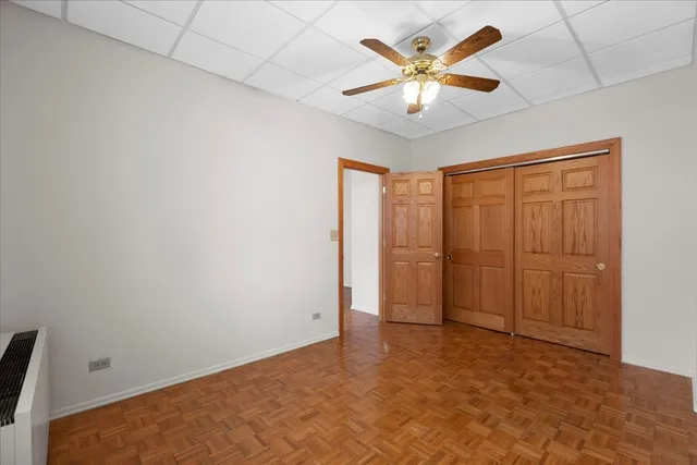 an empty room with closet and a ceiling fan