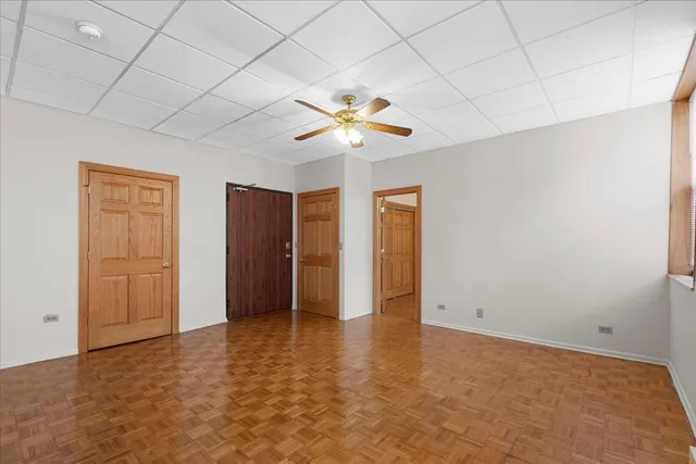 an empty room with closet and a chandelier fan