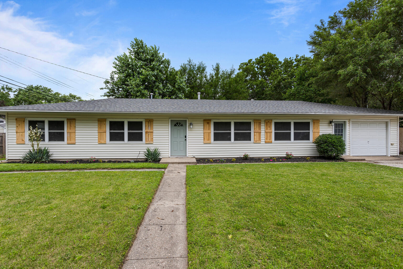 a front view of house with yard and green space