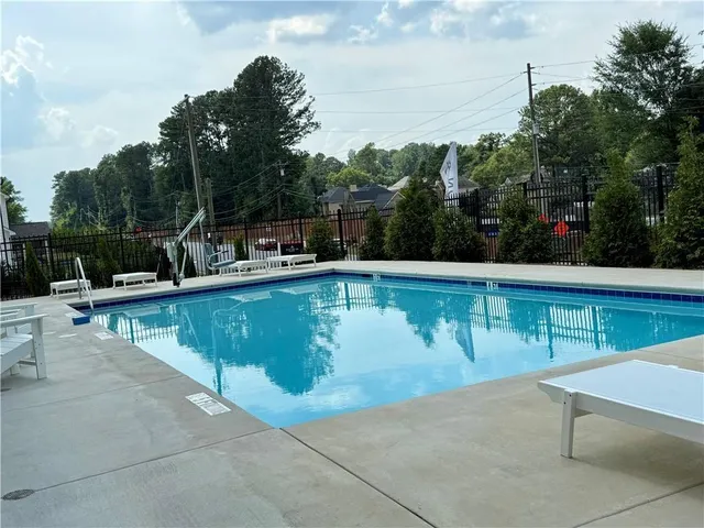 a view of a swimming pool with chairs in the patio