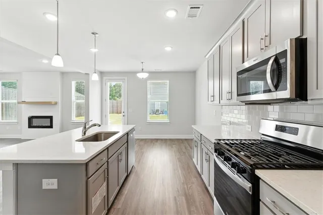 a kitchen with stainless steel appliances granite countertop a sink stove and refrigerator