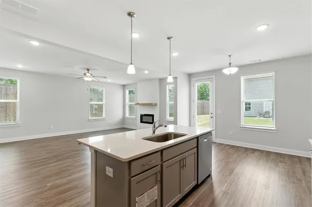 a kitchen with a sink dishwasher and a large window with wooden floor