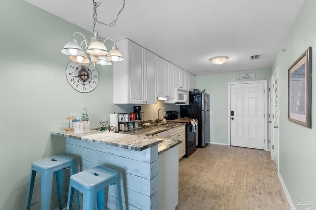 a kitchen with a table chairs refrigerator and cabinets