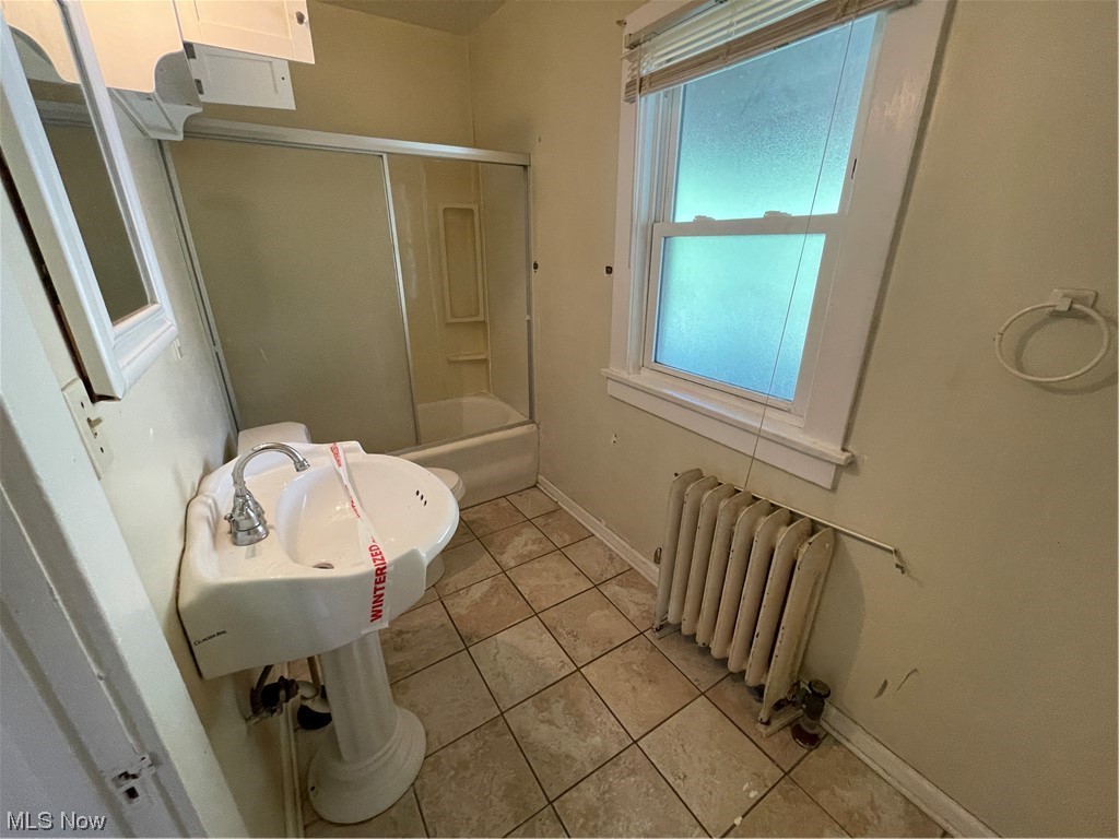 1730 Wood Road Cleveland Heights, OH 44121 - Photo 20 of 34 Bathroom with washbasin, radiator, bath / shower combo with glass door, and light tile floors