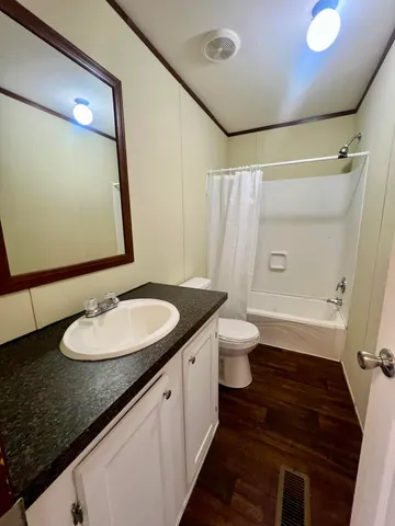 a bathroom with a granite countertop sink toilet and shower
