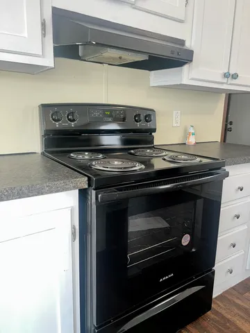 a stove top oven sitting inside of a kitchen