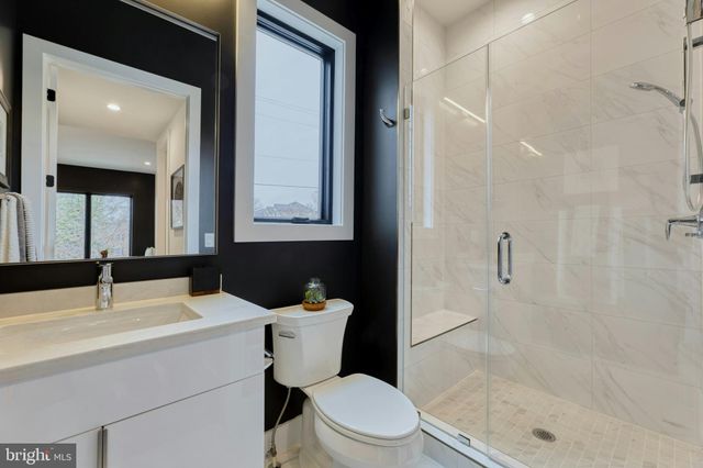 a bathroom with a sink toilet vanity and shower