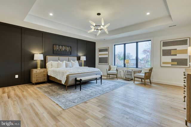 a bedroom with a bed and large windows