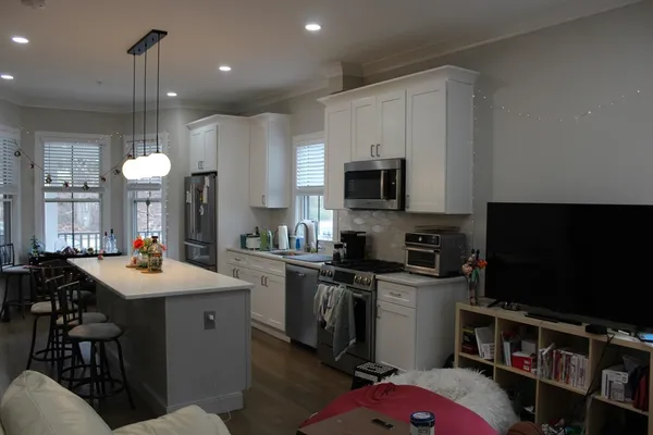 a kitchen with kitchen island a sink stove and microwave