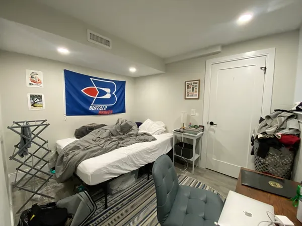 a bedroom with a bed and wooden floor