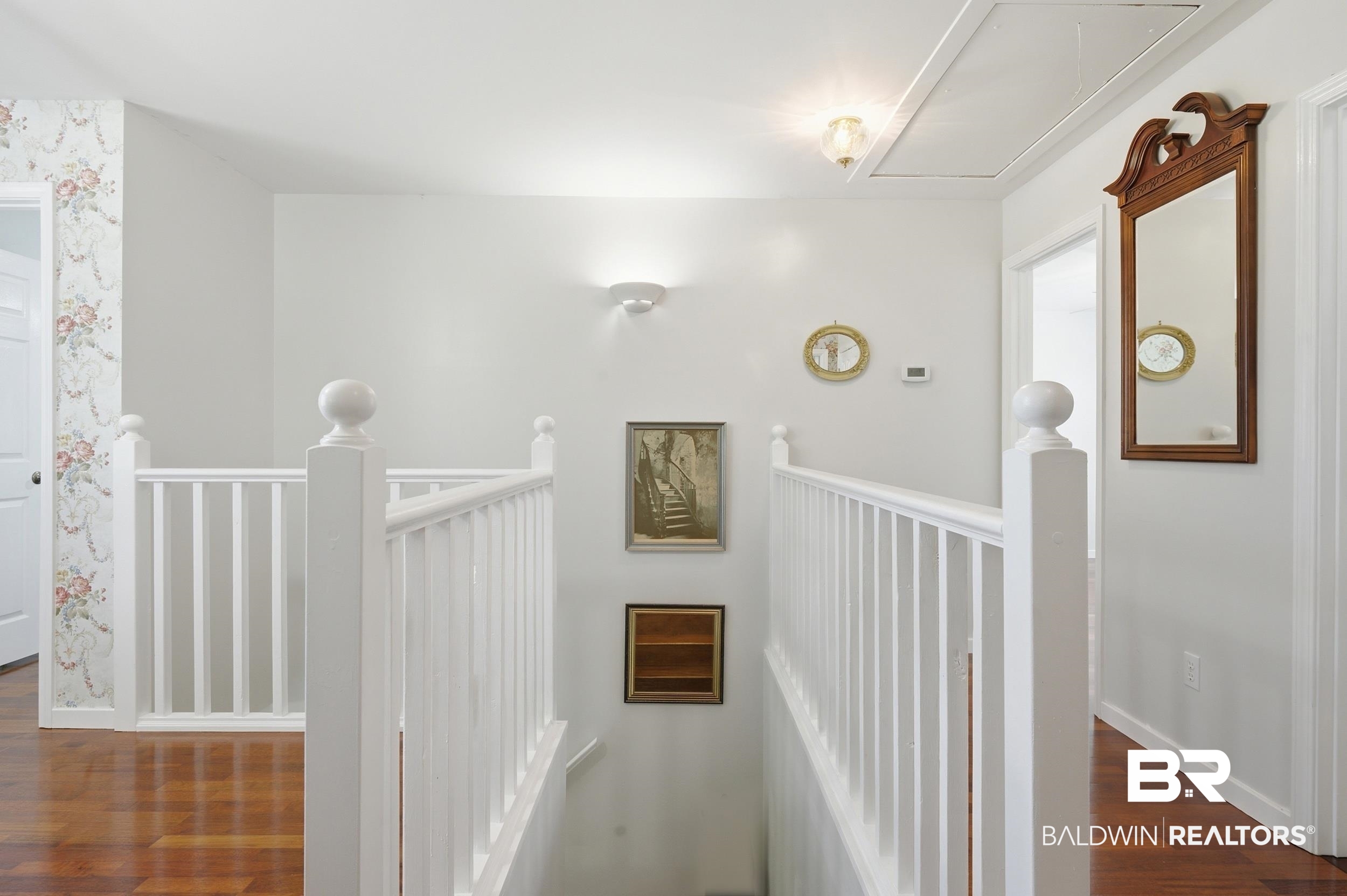 15855 Calvin Richerson Road Bay Minette, AL 36507 - Photo 46 of 83 Upper-level landing featuring wood-finish flooring, white balustrade, white walls, and a ceiling-mounted light fixture