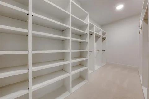 a view of walk in closet with empty racks