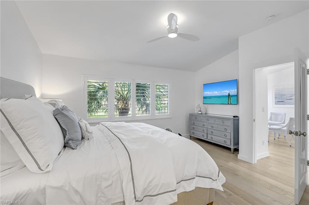 8345 Excalibur Circle, Unit M4 Naples, FL 34108 - Photo 12 of 19 a bedroom with a bed and a chandelier