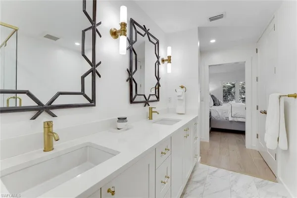a bathroom with double vanity sink and mirror