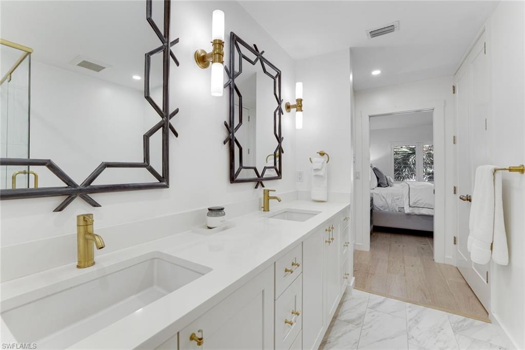 8345 Excalibur Circle, Unit M4 Naples, FL 34108 - Photo 13 of 19 a bathroom with double vanity sink and mirror