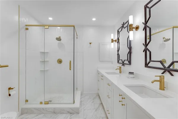 a bathroom with a double vanity sink mirror and shower