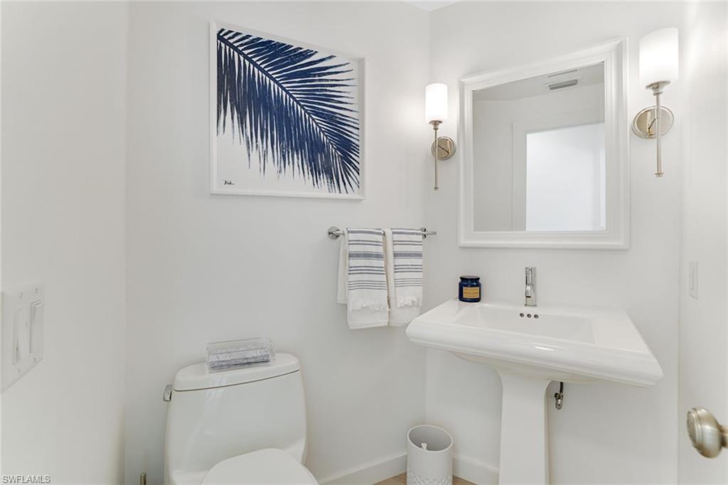 8345 Excalibur Circle, Unit M4 Naples, FL 34108 - Photo 18 of 19 a bathroom with a toilet a sink and mirror