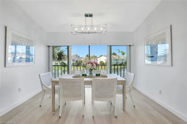 a dining room with furniture a large window and wooden floor