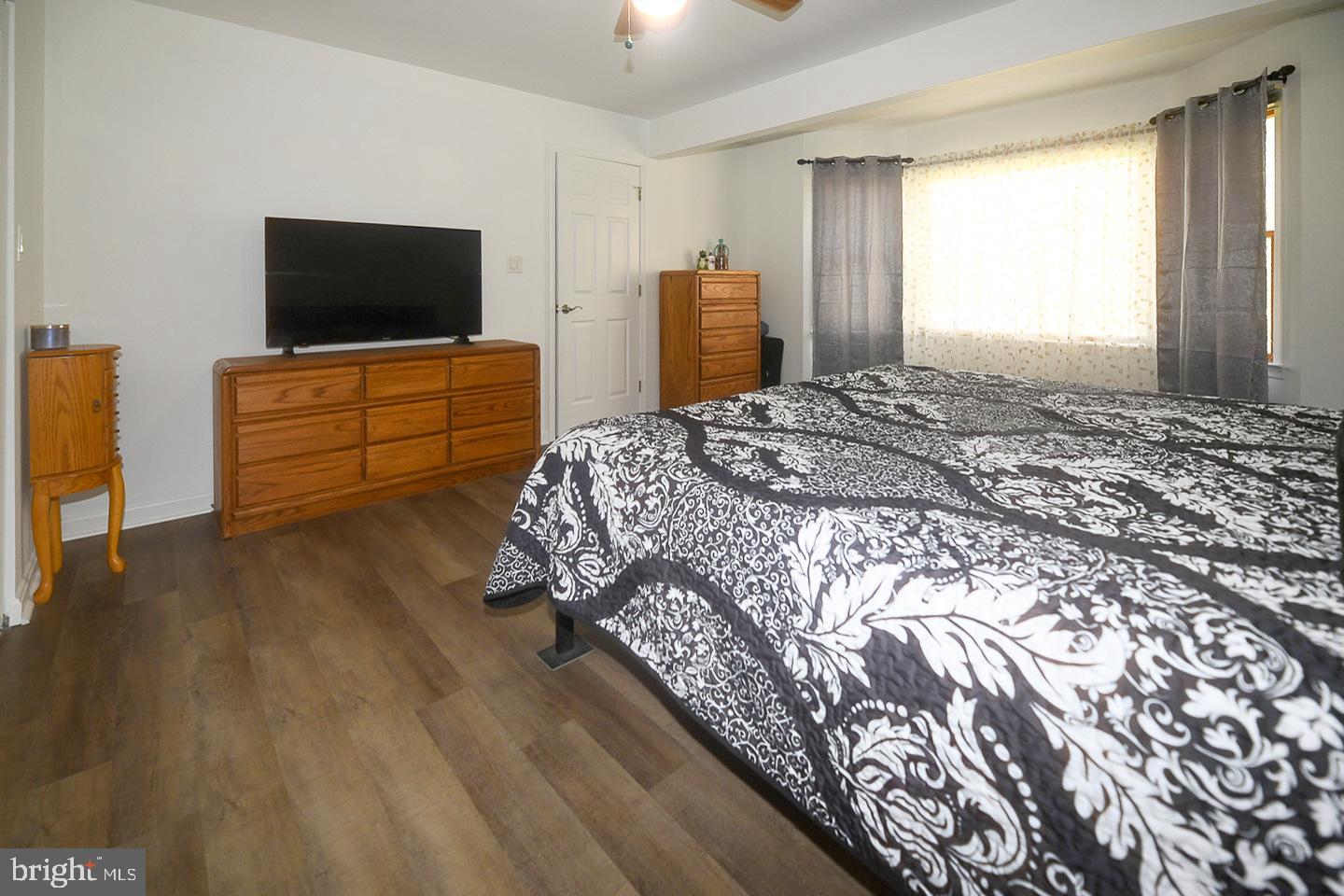 605 Planters Wharf Road Lusby, MD 20657 - Photo 12 of 45 a bedroom with bed and flat tv screen on dresser