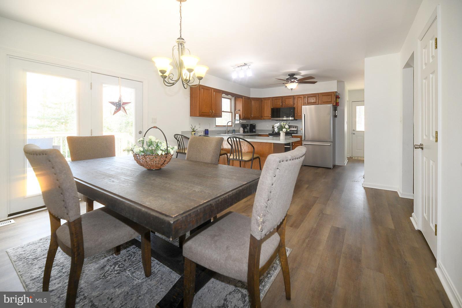 605 Planters Wharf Road Lusby, MD 20657 - Photo 4 of 45 a dining room filled chandelier and wooden floor