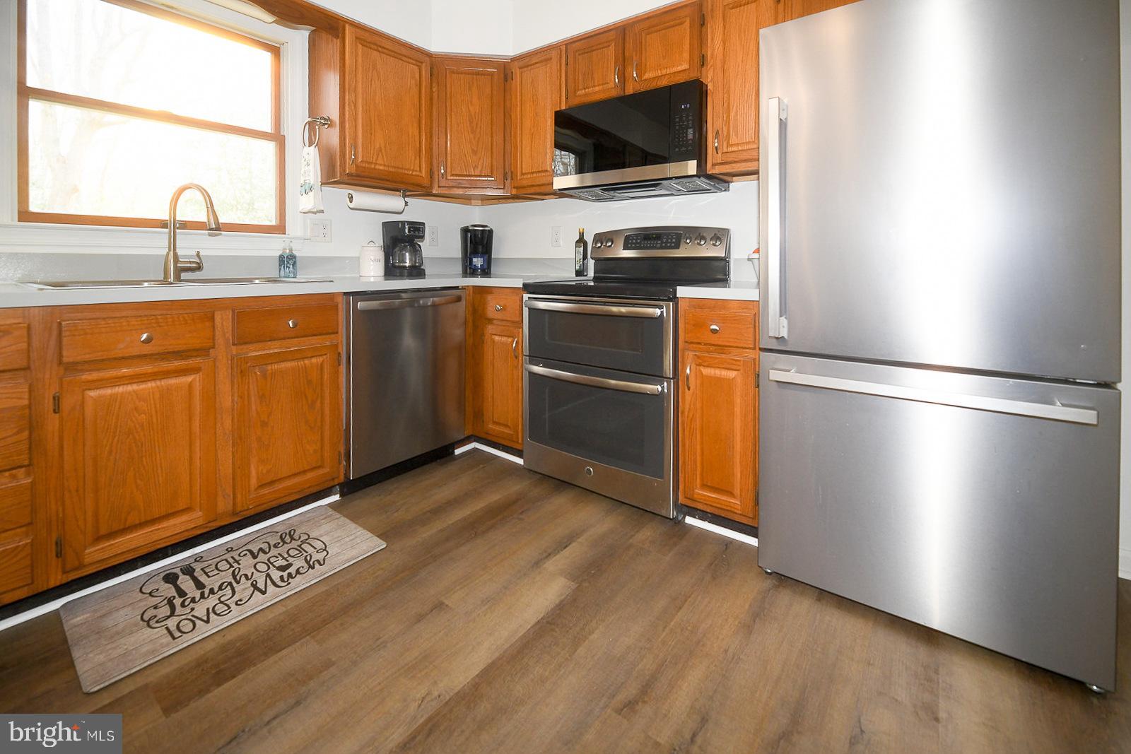 605 Planters Wharf Road Lusby, MD 20657 - Photo 8 of 45 a kitchen with granite countertop stainless steel appliances a stove top oven a sink a refrigerator and wooden floors