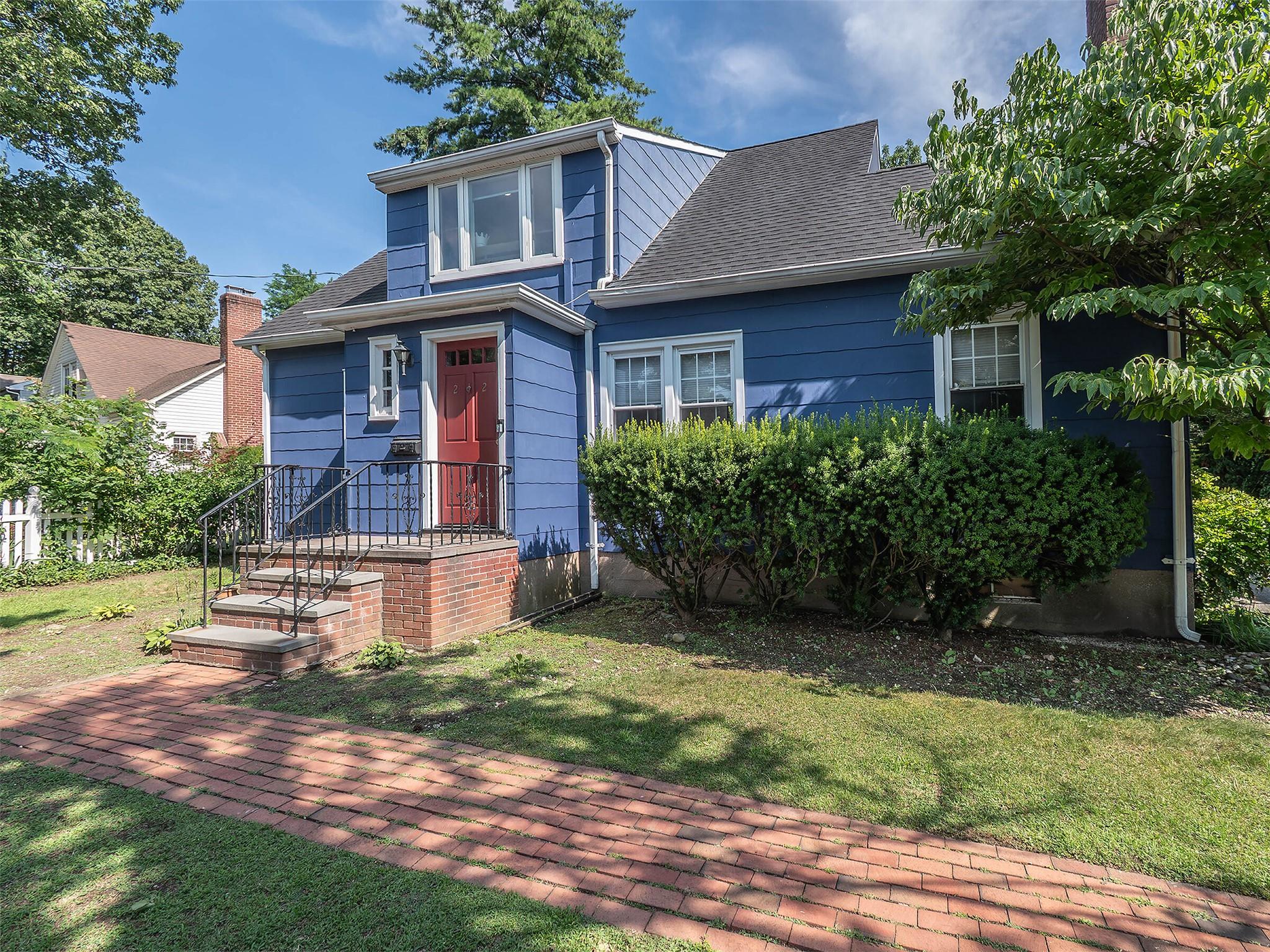 View of front facade featuring a front lawn and roof with shingles