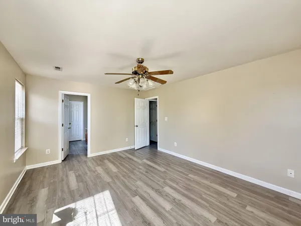 a view of a livingroom with wooden floor and a ceiling fan