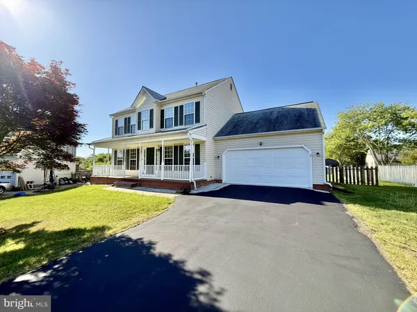 a front view of house with yard and trees in the background