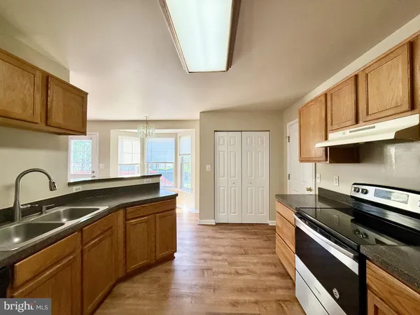 a kitchen with stainless steel appliances granite countertop a sink stove and cabinets