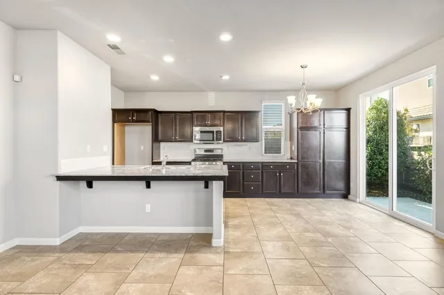 a large kitchen with kitchen island granite countertop a large counter top and stainless steel appliances