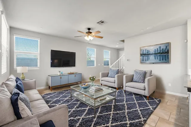 a living room with furniture a flat screen tv and a chandelier
