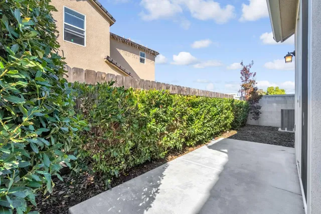 a front view of a house with a yard and potted plants