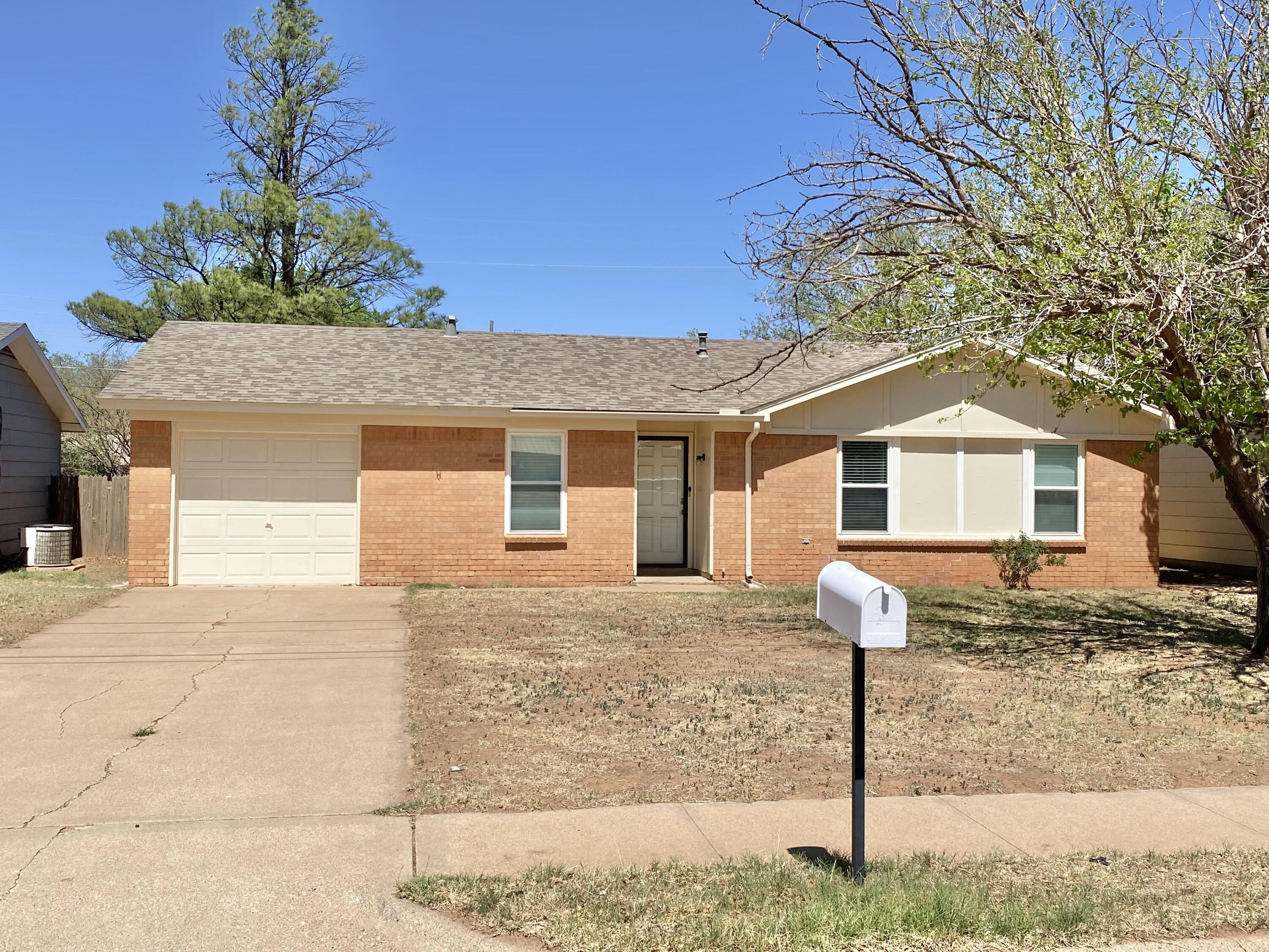 a front view of a house with a tree