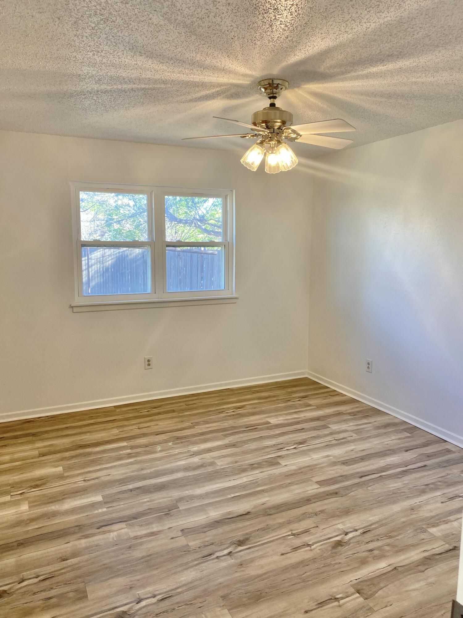 2128 74th Street Lubbock, TX 79423 - Photo 11 of 15 a view of empty room with wooden floor and fan