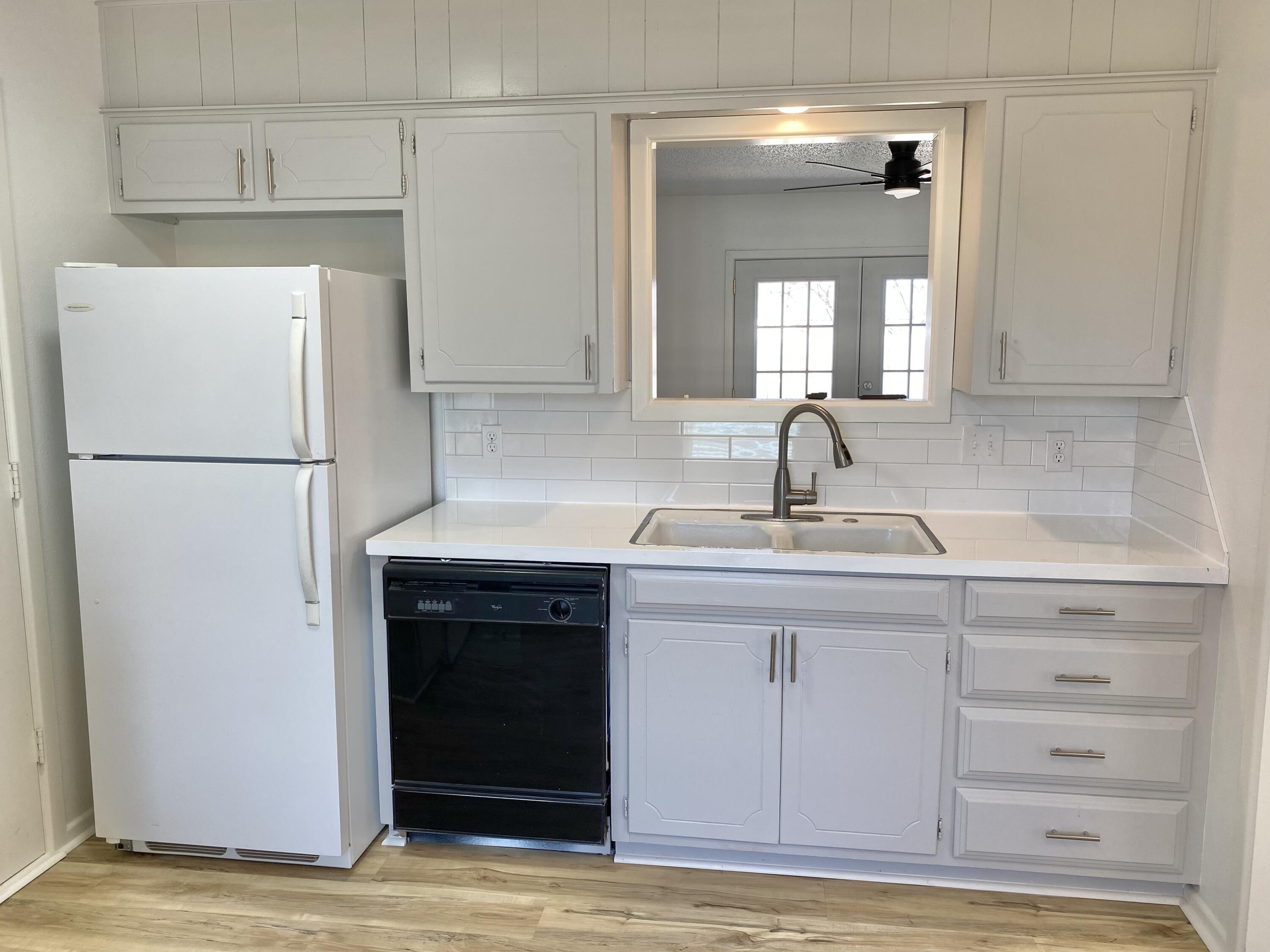 2128 74th Street Lubbock, TX 79423 - Photo 3 of 15 a kitchen with a sink and a refrigerator