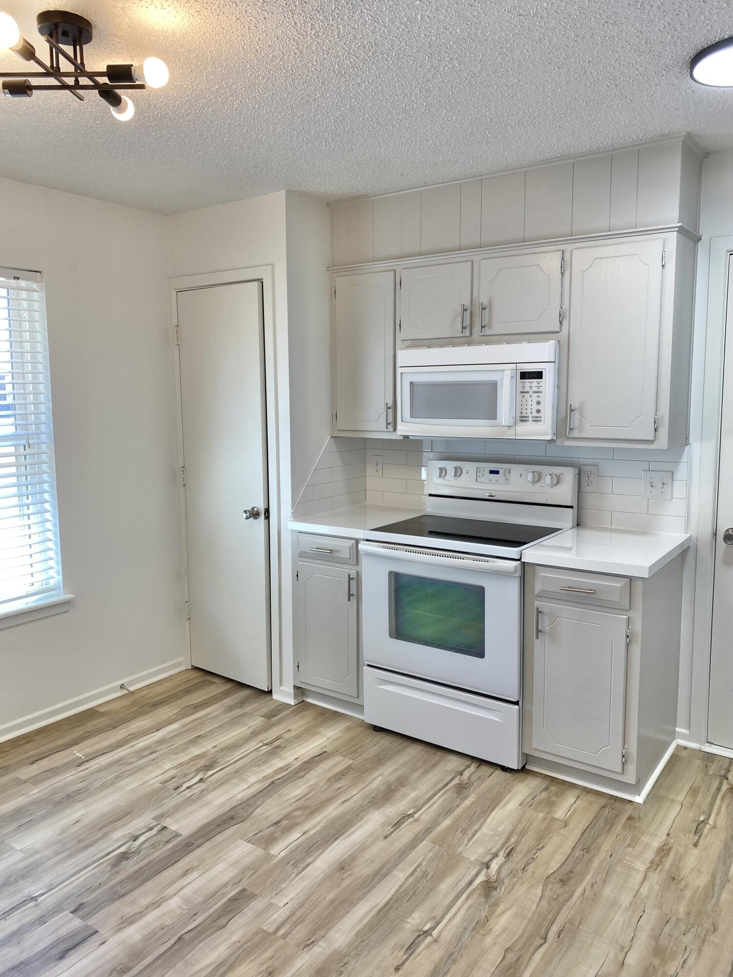 2128 74th Street Lubbock, TX 79423 - Photo 4 of 15 a kitchen with a stove oven and white cabinet