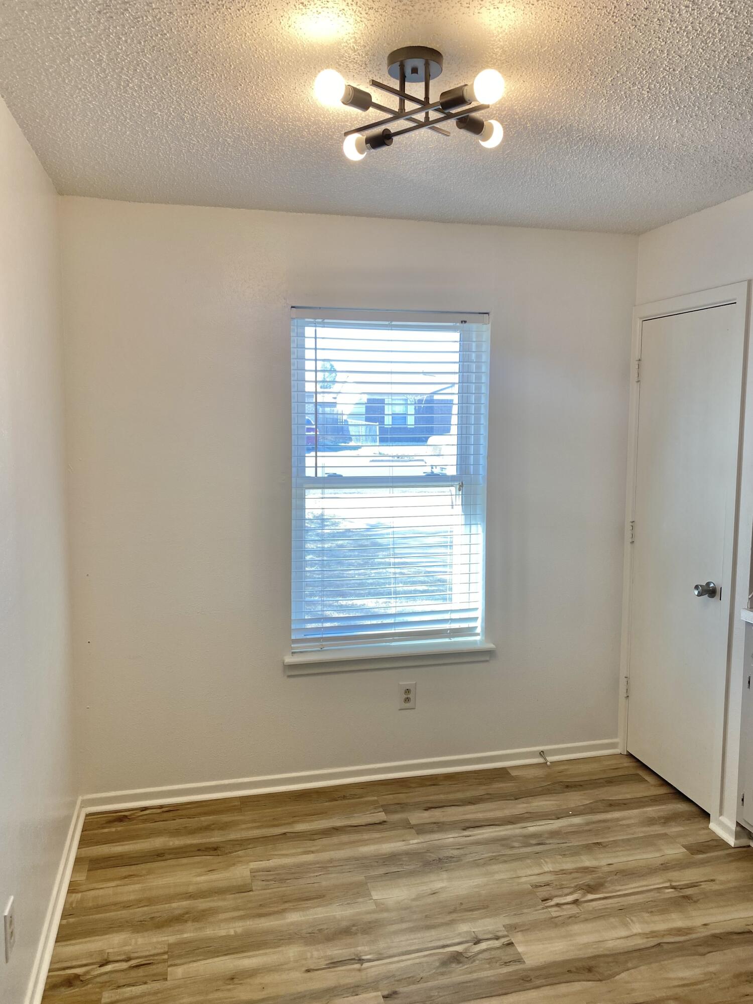 2128 74th Street Lubbock, TX 79423 - Photo 5 of 15 an empty room with wooden floor fan and windows