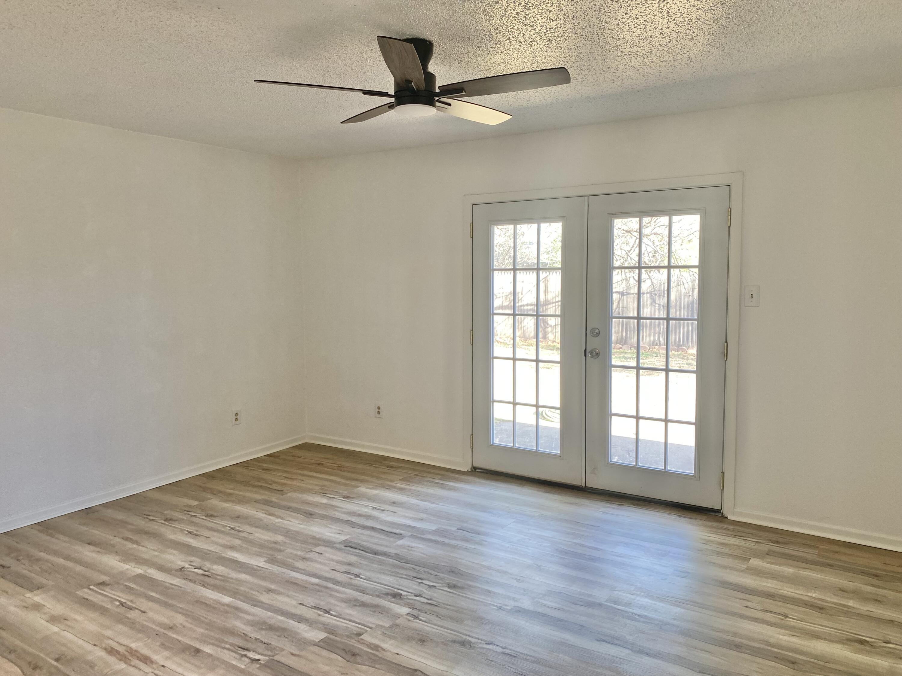 2128 74th Street Lubbock, TX 79423 - Photo 7 of 15 wooden floor in an empty room with a window
