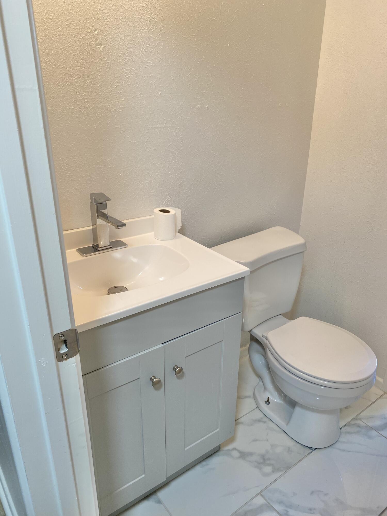 2128 74th Street Lubbock, TX 79423 - Photo 8 of 15 a white toilet sitting next to a bathroom sink