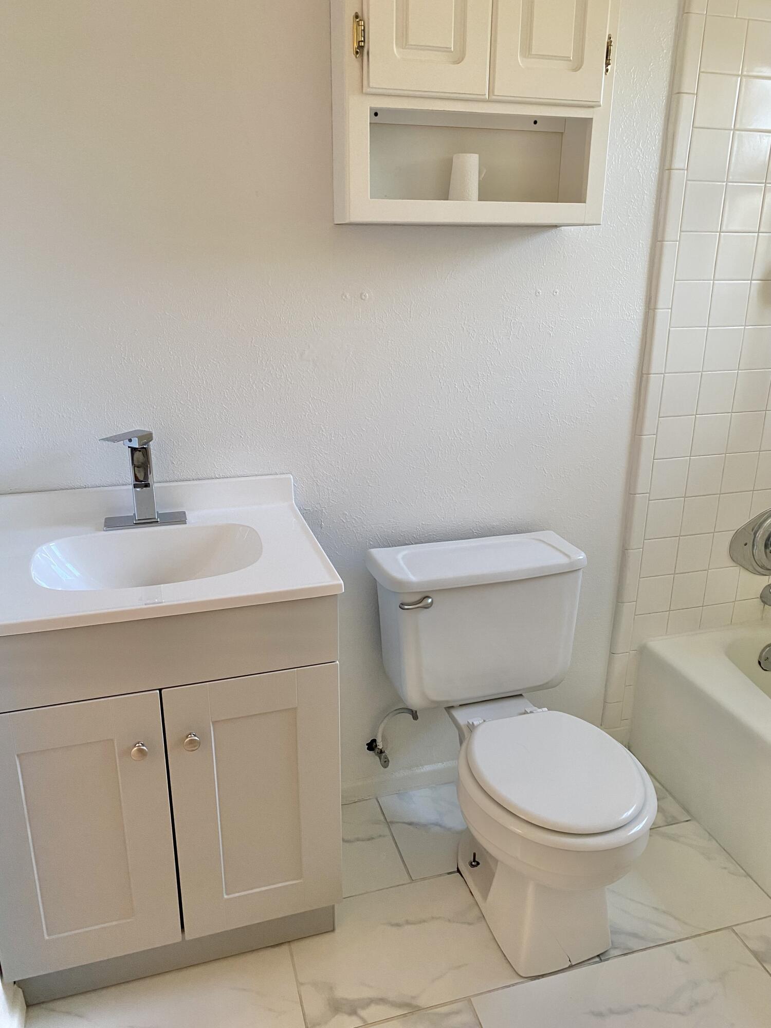 2128 74th Street Lubbock, TX 79423 - Photo 9 of 15 a white toilet sitting next to a bathroom sink