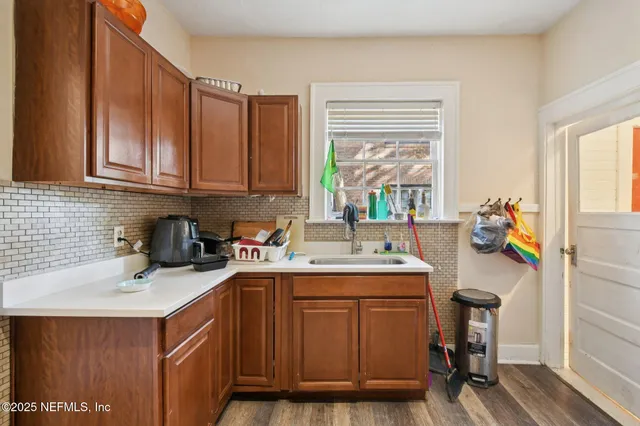 a kitchen with a sink a stove cabinets and a window