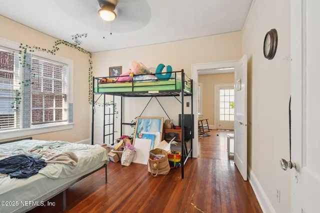 a bedroom with a bed and large windows