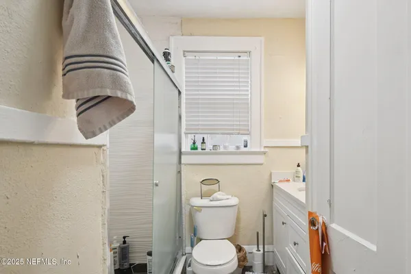 a bathroom with a toilet a sink and a mirror