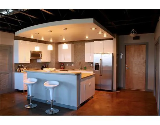 a kitchen with stainless steel appliances granite countertop a sink a stove and a refrigerator